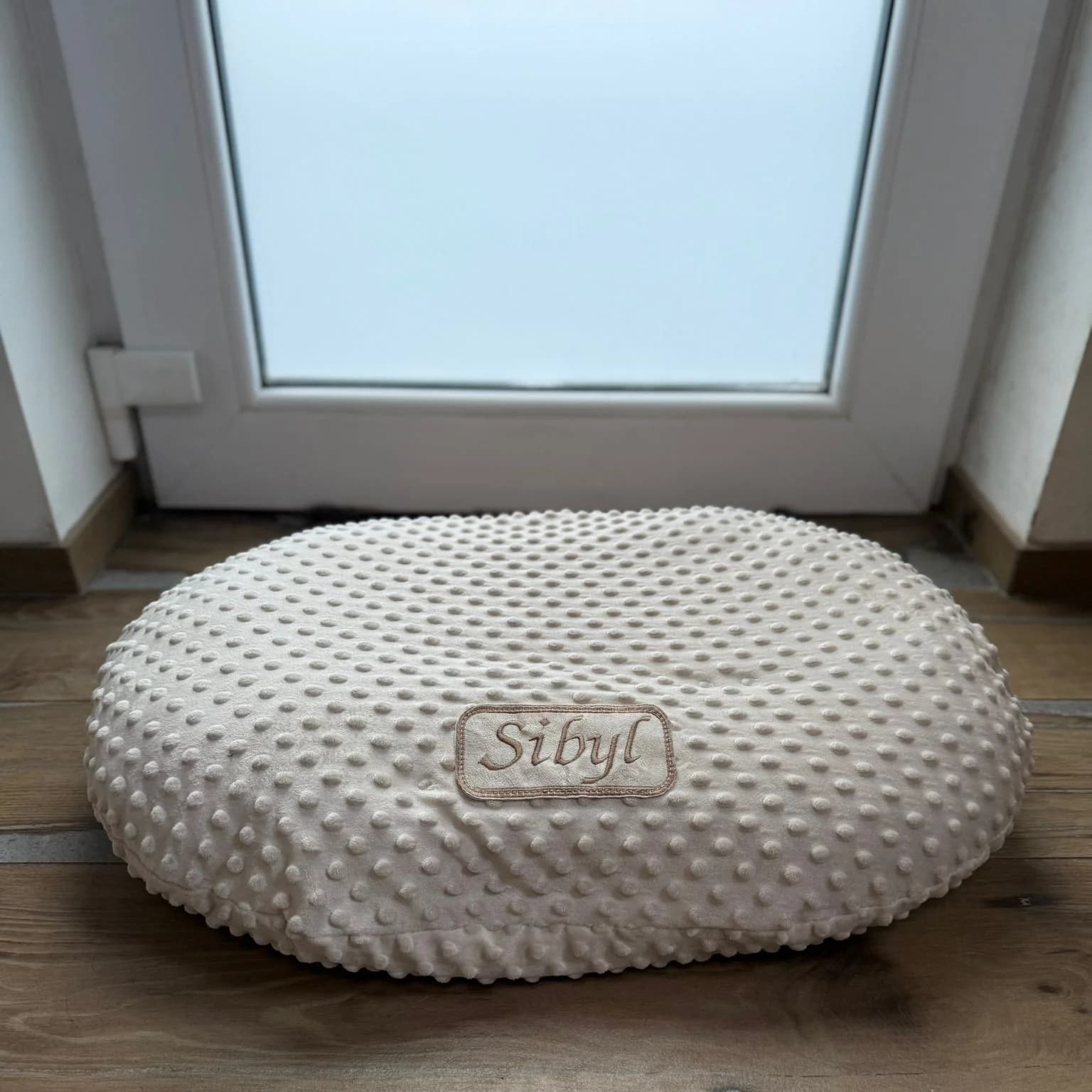 Coussin ovale déhoussable en tissu à pois beige, plaque brodée cousue